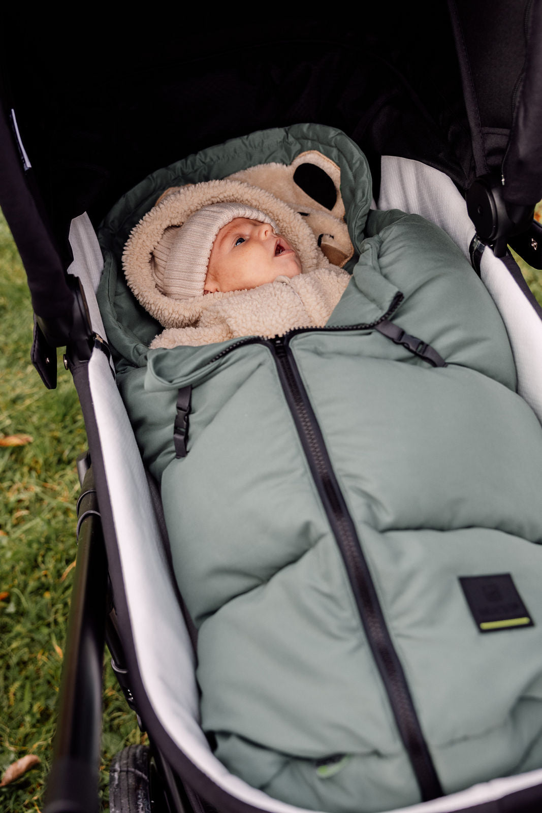 Fußsäckchen Mucki 2.0 liegt in Babywanne und Baby kuschelt sich darin ein
