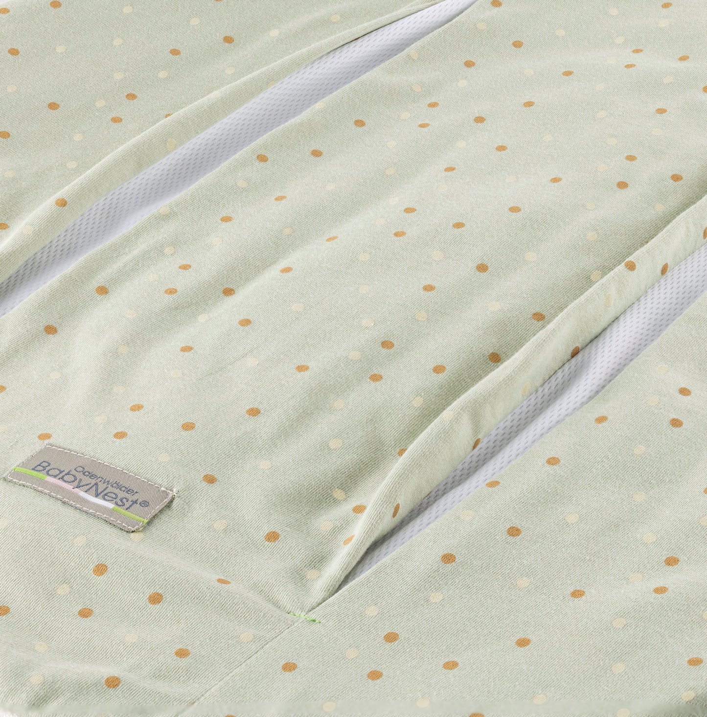 Detailaufnahme des prima klima Jersey‑Schlafsacks für Babys in der Designvariante Dotty mit mehreren kleinen Punkten auf hellem Stoff und sichtbarer Reißverschlussöffnung samt Jersey‑Materialstruktur, freigestellt dargestellt.
