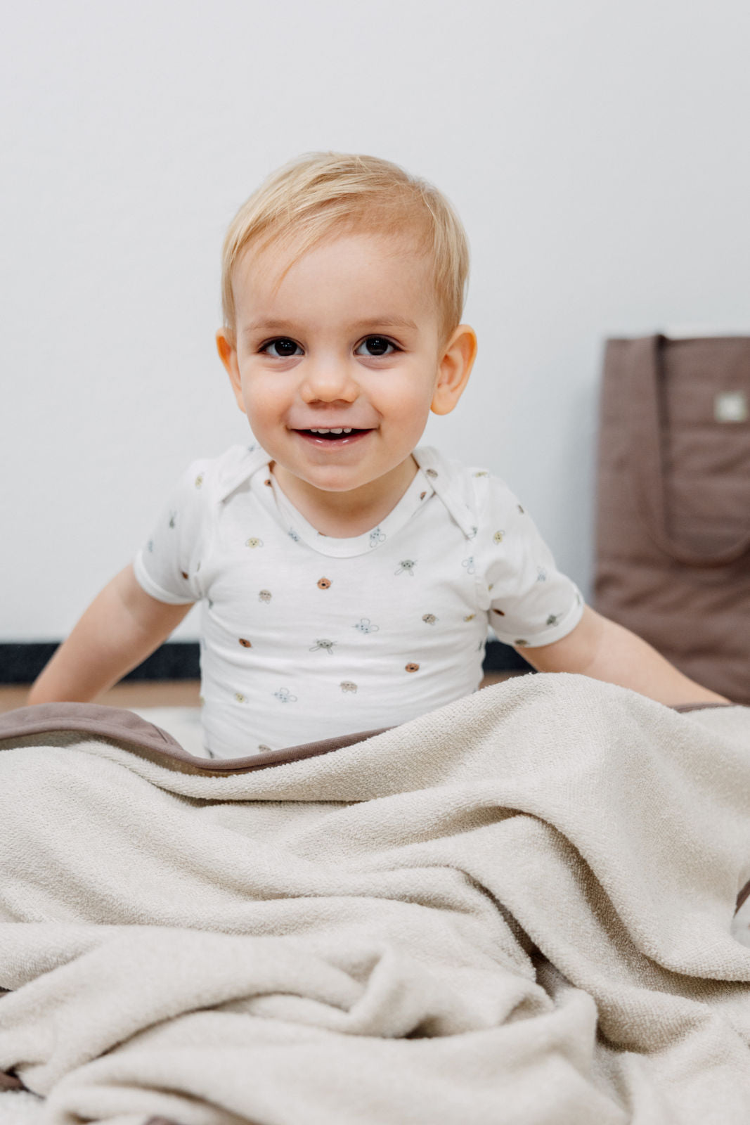 Kind trägt den Organic Cotton Baby Body Kurzarm im Design snuggles
