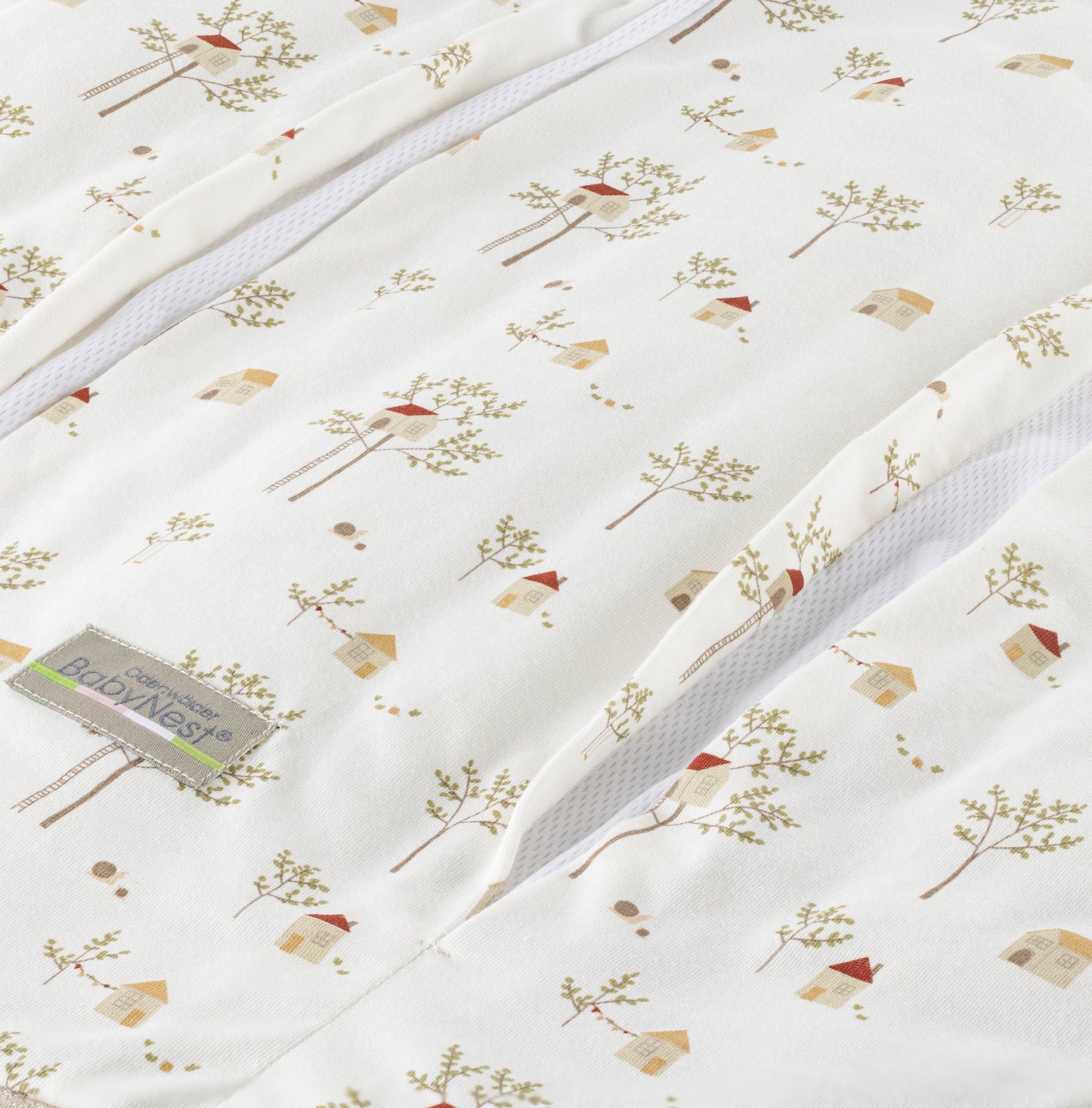 Detailaufnahme des prima klima Jersey‑Schlafsacks für Babys in der Designvariante Treehouse mit mehreren Baumhaus-Muster auf hellem Stoff und sichtbarer Reißverschlussöffnung samt Jersey‑Materialstruktur, freigestellt dargestellt.