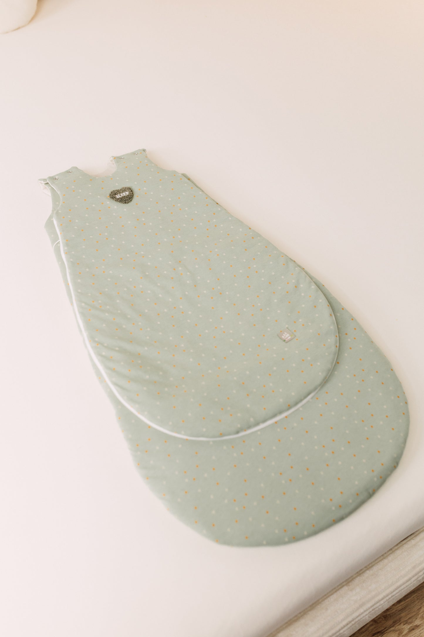 Übersicht des Ganzjahres mitwachsenden Jersey-Schlafsacks in der Designvariante Dotty, mit kleinem und großem Vorderteil übereinander liegend, um die Mitwachsfunktion zu verdeutlichen.